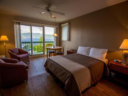 Cette chambre d'hôtel comprend un lit et un balcon. dans l'établissement Chalets Condos sur le Fjord, à LʼAnse-Saint-Jean