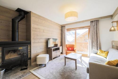 a living room with a couch and a fireplace at Residence l Hevana - maeva Home in Méribel