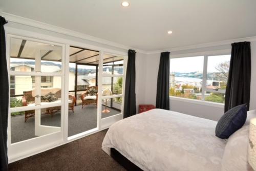 a bedroom with a bed and a view of a patio at City Views on Rattray in Dunedin