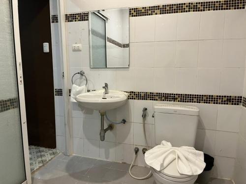 a bathroom with a toilet and a sink at Cozy rooms Asoke in Bangkok