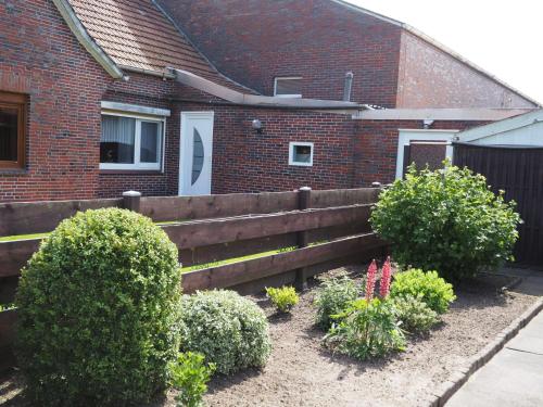 a wooden fence in front of a house at Ferienhaus Irma 35530 in Uplengen