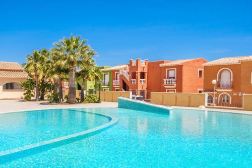 einen Pool in einer Villa mit Palmen und Häusern in der Unterkunft Casa Frederyk in Cumbre del Sol