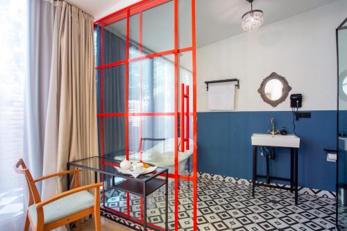 um quarto com uma mesa de vidro e um lavatório em Shota Rustaveli Aparthotel em Tbilisi