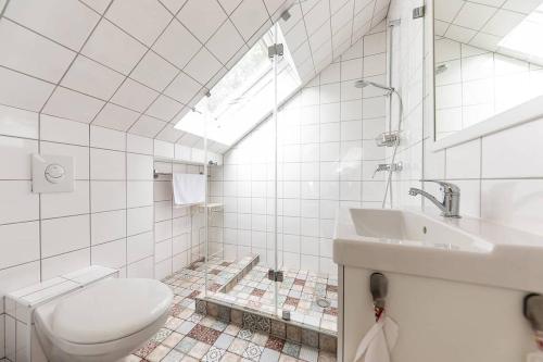 a white bathroom with a toilet and a sink at Magnólia in Nagykanizsa