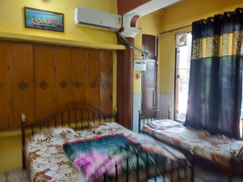 a bedroom with two beds in a room with a window at Hotel Darpan By WB Inn in Jammu