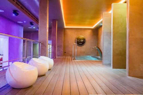 a bathroom with a tub and a row of white chairs at Moon Hotel & SPA. in Aguadulce