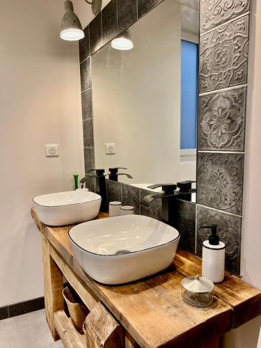 a bathroom with two sinks on a wooden counter at La Villa 1777 in Lagnes