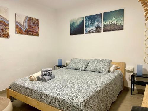 ein Schlafzimmer mit einem Bett und einige Gemälde an der Wand in der Unterkunft Apartamento el Cau, acogedor y cerca del Montseny in Arbúcies