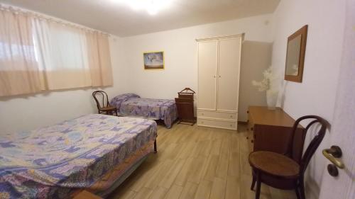 um quarto com 2 camas, uma mesa e uma secretária em L'Alba della Tavernetta em Locorotondo