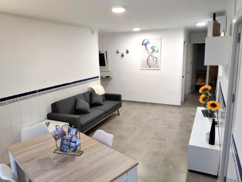 ein Wohnzimmer mit einem Sofa und einem Tisch in der Unterkunft Apartamento el Cau, acogedor y cerca del Montseny in Arbúcies