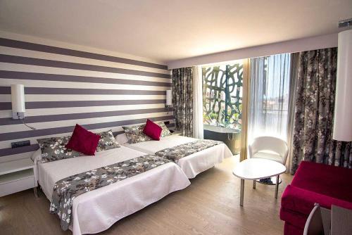 Hotel RH Vinarós Aura في فيناروس: غرفة فندقية بسريرين ونافذة