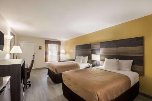Quality Inn & Suites near Lake Oconee في Turnwold: غرفة فندقية بسريرين ومطبخ