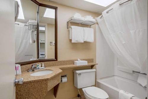 a bathroom with a toilet and a sink and a tub at Quality Inn & Suites in Ocean City
