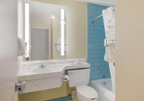 La salle de bains est pourvue d'un lavabo, de toilettes et d'un miroir. dans l'établissement Clarion Inn, à Hurley