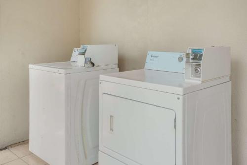 two white washing machines sitting next to each other at Econo Lodge Lake Charles University Area in Lake Charles