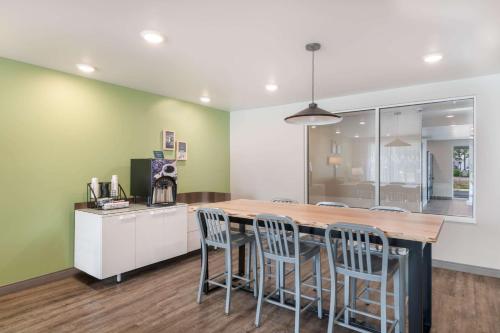 a kitchen with a wooden table and chairs at WoodSpring Suites Concord-Charlotte Speedway in Concord