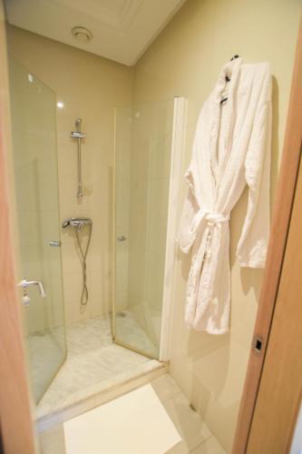 a bathroom with a shower and a robe hanging on the wall at YourPlace - Prestigia - Hay Riad in Rabat