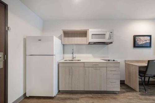 a kitchen with a white refrigerator and a microwave at WoodSpring Suites Concord-Charlotte Speedway in Concord