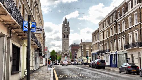 uma rua da cidade com uma torre do relógio à distância em Beautiful and modern House in Gravesend em Gravesend