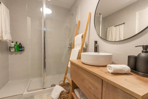 カルデス・デ・マラベーリャにあるBacom Apartmentのバスルーム(シンク、鏡付きシャワー付)