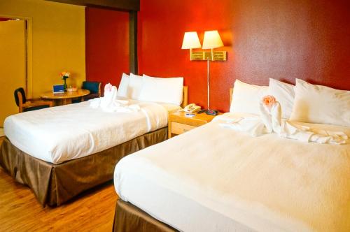 a hotel room with two beds with towels on them at OceanView Motel in Huntington Beach