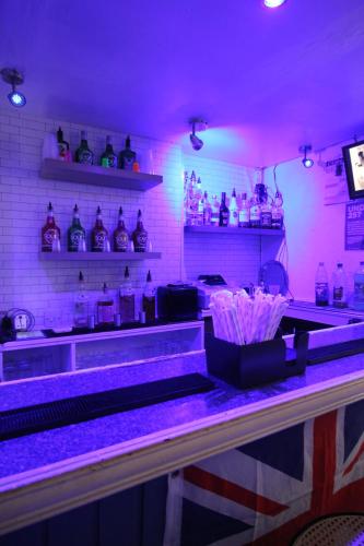 a bar with purple lighting in a restaurant at Jesmond International Hotel in Blackpool