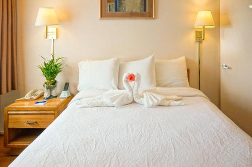 a bedroom with a bed with two stuffed animals on it at OceanView Motel in Huntington Beach