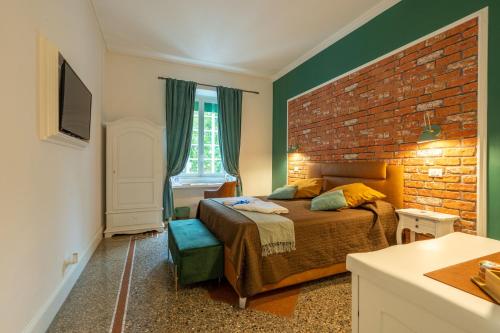 - une chambre avec un lit et un mur en briques dans l'établissement Capital Rooms, à Rome