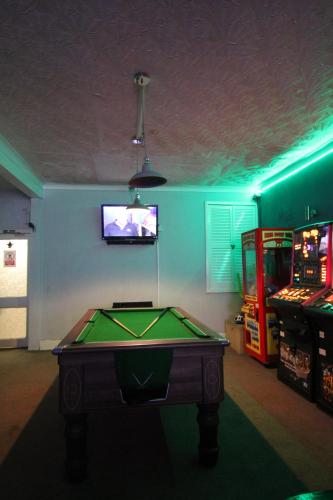 uma sala de jogos com uma mesa de bilhar e uma televisão em Jesmond International Hotel em Blackpool