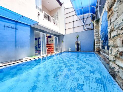 een zwembad in een gebouw met een blauwe muur bij Rumah Kartika Batu in Batu