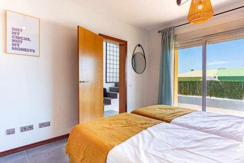 a bedroom with a bed and a large window at Villa Horizon in Caleta De Fuste