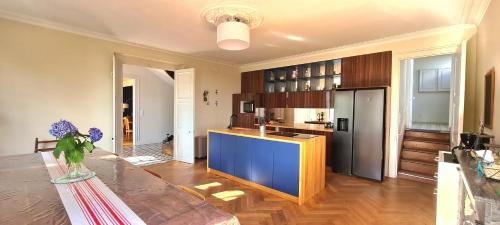 uma cozinha com uma mesa e um balcão azul em Les Hauts de St Jacques maison d'exception 300m2, jardin arboré 2000m2 em Pouzauges