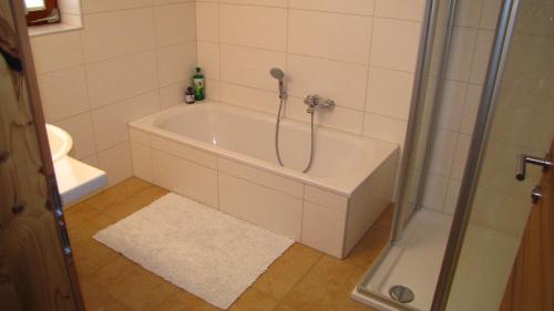 a bath tub in a bathroom with a shower at Apartments Röck in Neukirchen am Großvenediger