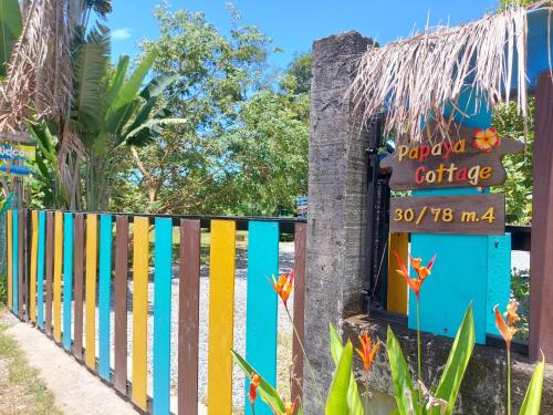 una valla de colores con un cartel que lee cartílago feliz en Papaya Cottage Koh Chang en Ko Chang