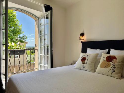 1 dormitorio con cama y ventana abierta en La Villa 1777 en Lagnes