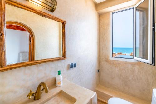 bagno con lavandino e specchio di Riad Kafila a Essaouira