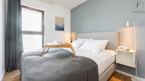 a bedroom with a bed with a table on it at Flatbook - City Center SPA Apartments Toruńska in Gdańsk