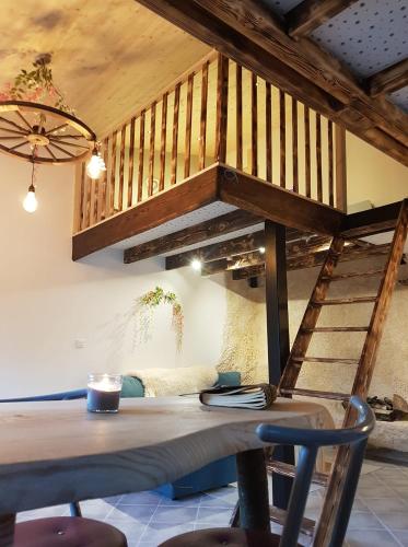 - une table et des chaises en bois dans une chambre avec un escalier dans l'établissement Gîte avec spa et sauna Aux champs des Amours, à Rocquigny