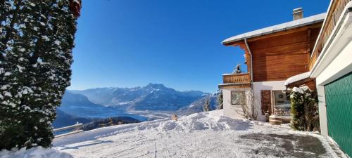 una casa en la nieve con vistas a las montañas en Magical Hideaway, en Leysin