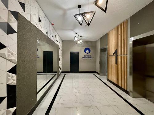 an empty hallway with a lobby with a door and tiles at Апартаменти-студія, дизайнерський ремонт, ЦЕНТР, біля Либідь Плаза in Khmelʼnytsʼkyy