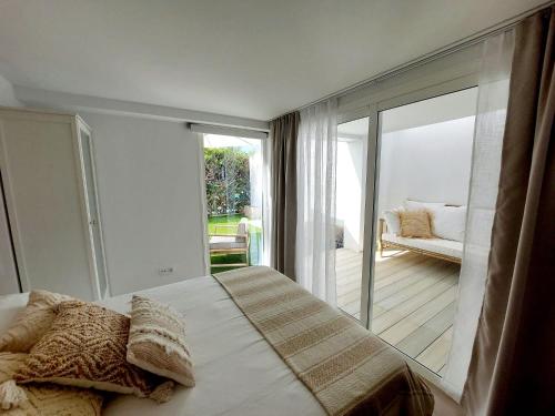 a bedroom with a bed and a sliding glass door at Bungalow de diseño hidromasajes terraza y piscina. in San Bartolomé de Tirajana
