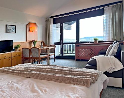 a hotel room with a large bed and a table and chairs at Apartman Mitterdorf in Philippsreut