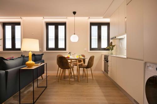 a kitchen and living room with a table and chairs at Palmeiras Apartment, by Bolhão Residences in Porto
