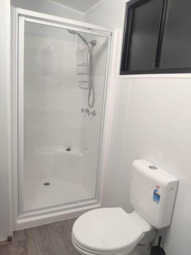 a white bathroom with a shower and a toilet at Holiday Retreat in Burbank