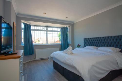 a bedroom with a large bed and a window at Botany Bay Holiday House - Family friendly, 50M from the beach in Kent