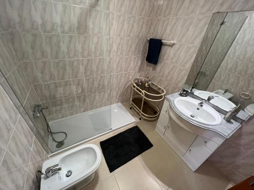 La salle de bains est pourvue d'un lavabo, de toilettes, d'une baignoire et d'un miroir. dans l'établissement Moradia com Alma Xico's House, à Coimbra