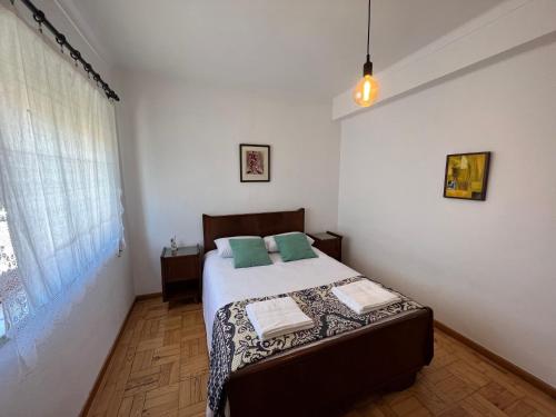 Un dormitorio con una cama con almohadas verdes. en Moradia com Alma Xico's House en Coimbra