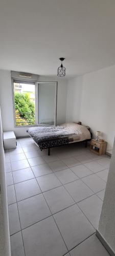 Superbe appartement COSY في مونبلييه: غرفة نوم مع سرير على أرضية من البلاط