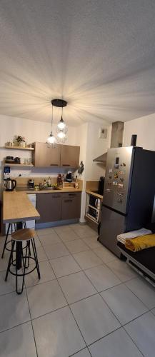 Superbe appartement COSY في مونبلييه: مطبخ كبير مع طاولة وثلاجة