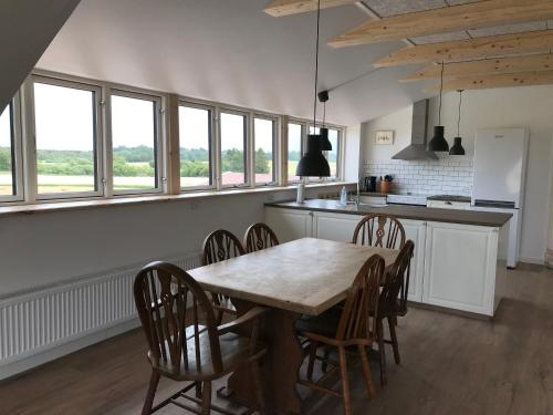 a kitchen and dining room with a table and chairs at Nordgården - ferie på landet in Skibby